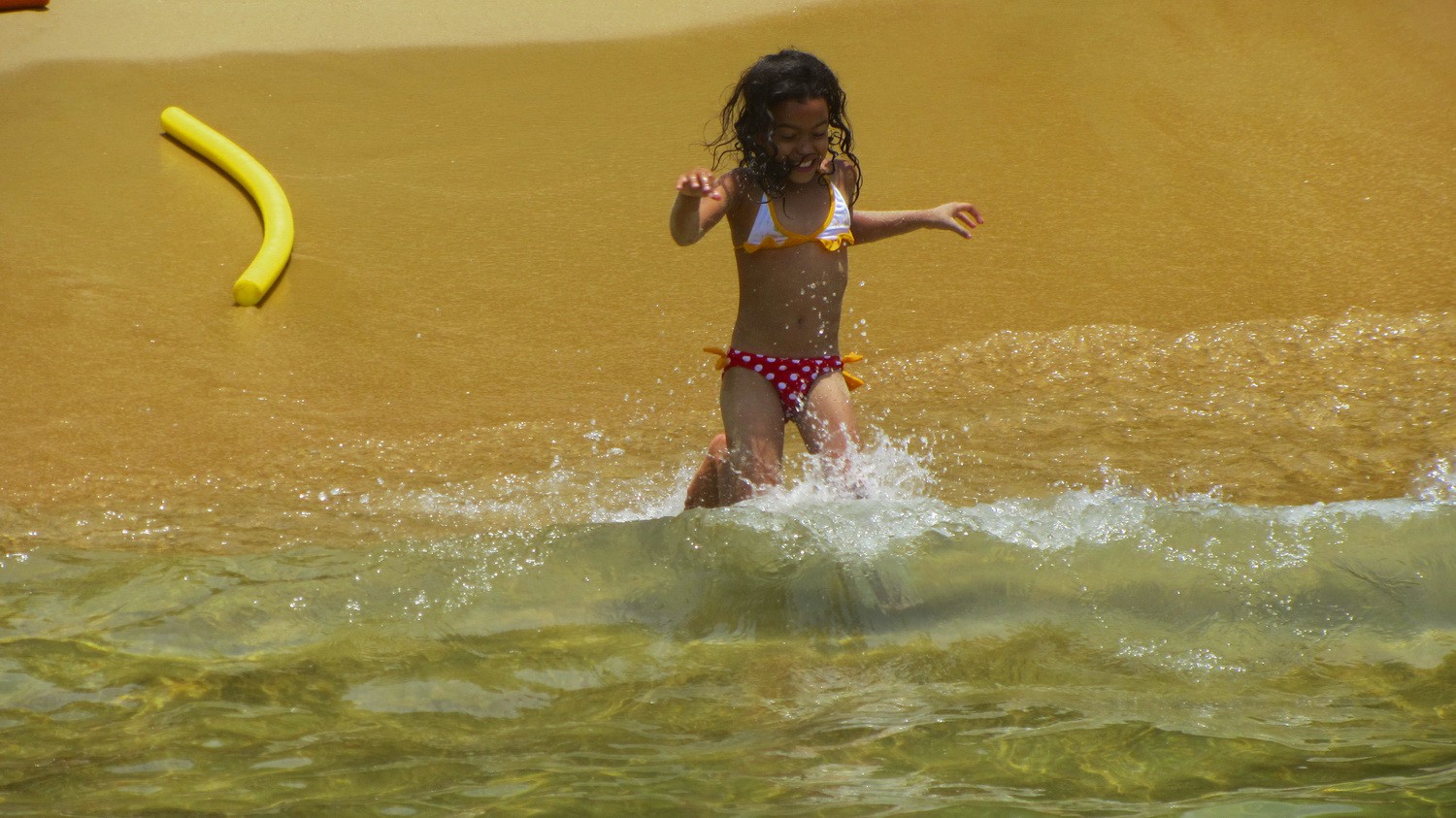Pretty girl running into the ocean